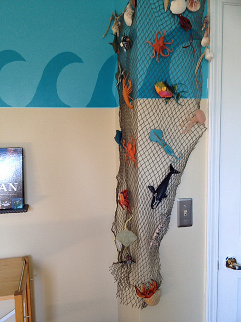 He loves to collect those plastic sea animals and I used a fishing net to display them on this corner in his room.